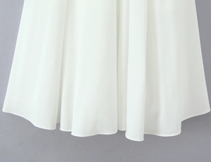 Gros plan de l'ourlet de robe en mousseline blanche montrant les coutures fines