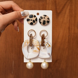 Detailed set of leopard print studs, marble resin pendants, and gold rimmed pearl earrings