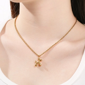 Détail d'un collier avec pendentif chien ballon doré porté montrant la texture 3D brillante