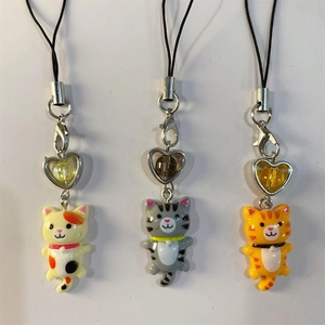 Detailed view of resin cat charms with heart beads and metal chains for phone or keys
