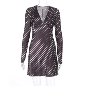 Detail of deep V-neckline and white polka dot pattern on the long-sleeved mini dress