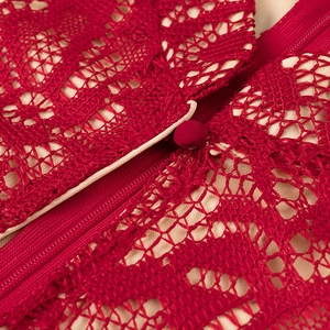 Detail of red lace dress showing invisible zipper and fabric-covered button on nude lining