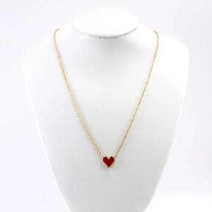 Detail of gold beaded red heart pendant on a stylish stainless steel necklace for women