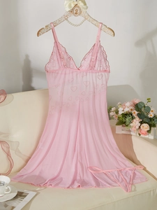 Détail d'une nuisette en résille rose à motifs cœurs sur un cintre en perles