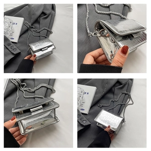 Detail view of silver crocodile pattern mini flap bag with metallic chain strap