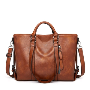 Detail of a brown PU leather tote bag with vintage texture and gunmetal zip pocket