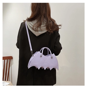 Rear view of model wearing a gothic purple bat-shaped PU leather crossbody shoulder bag