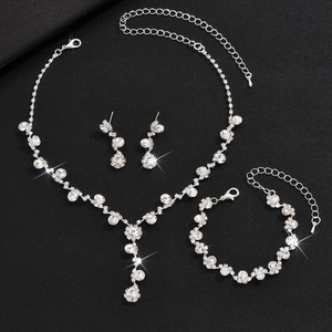 Detailed close-up of sparkling rhinestone necklace, bracelet and earrings set on black