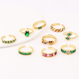 Detail of 9-piece gold adjustable ring set with green emerald cubic zirconia stones