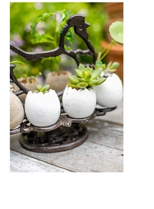 Détail du support coq en fonte vintage avec pots en coquille d'œuf et succulentes