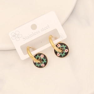 Detail of gold round earrings with black enamel pink flower and green vine charms