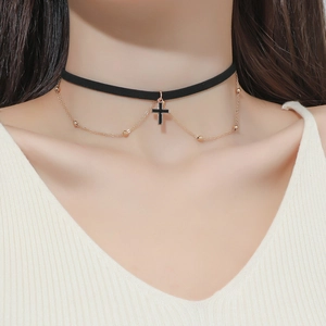 Dettaglio choker nero con ciondolo a croce e catenina dorata a sfere stile multistrato