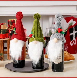Detailed view of three knitted gnome wine bottle covers in red, green and grey colors