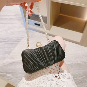 Elegant black evening clutch bag with pleated fabric, pearl handle, and pearl clasp detail