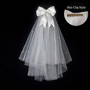 Short white bridal veil with large satin bow and pearls, featuring hair clip attachment