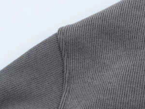 Macro view of dark grey ribbed knit fabric texture and high-quality shoulder stitching