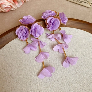 Detail of light purple chiffon flower tassel earrings with golden alloy accents