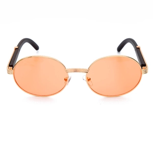 Detalle de gafas de sol retro con lentes naranjas, montura dorada y patillas de madera