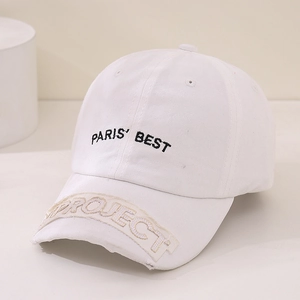 Detail of Paris Best embroidery and distressed Project patch on white cotton baseball cap