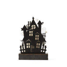 Macro view of a black wooden Halloween ghost house silhouette with fence and star details
