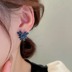 Elegant deep blue zircon butterfly stud earrings shown on ear for a chic aesthetic