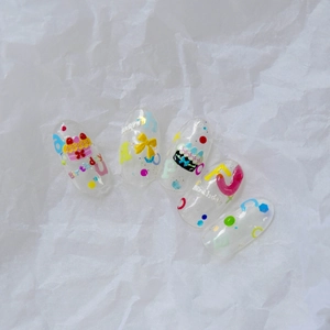 Detail of embossed birthday cake nail stickers with colorful polka dots and bows