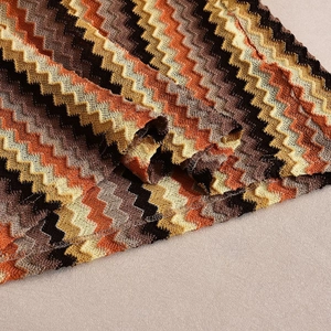 Detailed macro shot of the colorful wave-patterned knit fabric on the V-neck dress