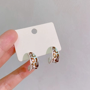 Close-up of vintage leopard print C-shape hoop earrings on a white card display