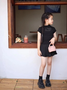 Modische rosa Mini-Muscheltasche für Kinder, kombiniert mit einem schwarzen Outfit