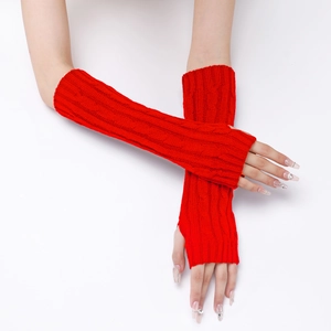 Detail of red cable knit fingerless gloves with classic twist pattern on white background