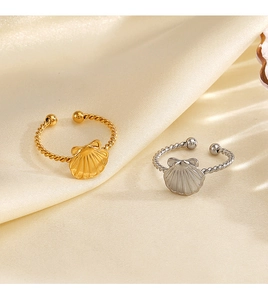 Detail showing gold and silver shell rings with twisted bands on elegant silk fabric