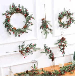 Detail of Christmas wreath components including red berries, pine cones and green foliage