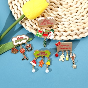 Detailed close-up of four Christmas enamel brooches with festive pendants and metal charms