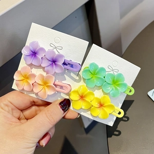 Detail view of colorful frangipani flower hair clips on card for children and girls