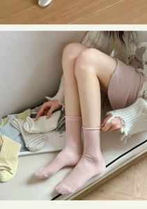 Detail of ribbed cotton socks in macaron colors like pink and blue with rolled cuffs