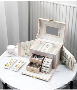 Detailed top view of large multi-layer jewelry box with compartments and gold hardware