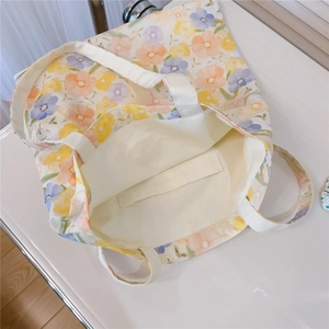 Detail view showing the soft yellow inner lining and open interior pocket of the tote bag
