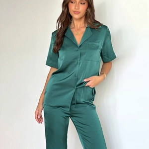 Detail view of dark green satin pajama set featuring a lapel short sleeve top and long pants
