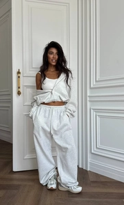 Détails d'un ensemble hoodie gris zippé, débardeur blanc et pantalon de jogging large