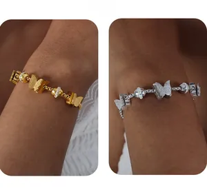 Détail des bracelets papillon en or et argent ornés de perles de cristal brillantes