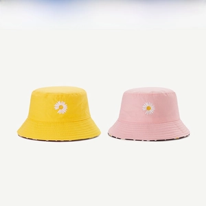 Detail of yellow and pink cotton bucket hats with daisy embroidery and floral lining