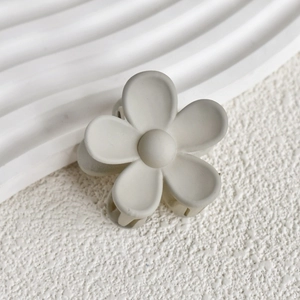 Nahaufnahme einer matten beige Blumen-Haarklammer mit minimalistischem Fünf-Blatt-Design