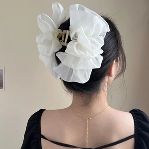 Detail view of large white double-layer mesh bow hair claw clip worn on a clean hairstyle