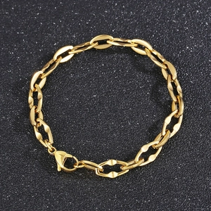 Detail of a golden oval link chain with a lobster clasp on a black textured background