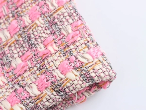 Vue macro de la texture en tweed rose montrant les fibres tissées et détails du fil