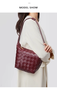 Side view of model wearing a deep burgundy woven leather shoulder bag with a soft texture