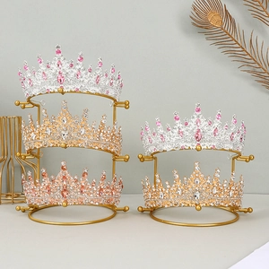 Three-tier gold metal tiara display stand featuring luxurious rhinestone bridal crowns