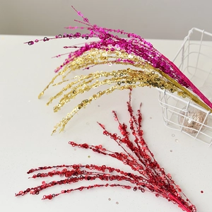 Glittering Christmas sequin branches in red, gold, and magenta for festive tree decoration