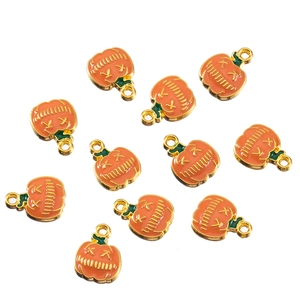 Flat lay view of 11 alloy pumpkin charms with orange enamel for DIY Halloween jewelry