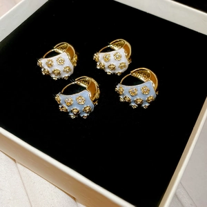 Close-up of vintage flower C-shape hoop earrings with enamel and rhinestones